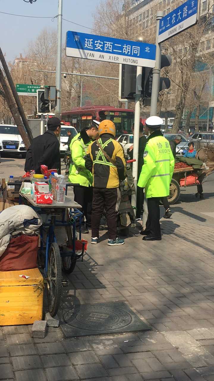 美团小哥在给医院送餐,车子停到了路边,被交警扣住了,罚了两百块钱,扣