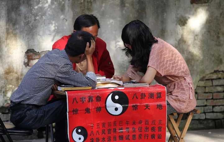 2011年9月25日,江苏省南通市一路边算命摊上,一对青年男女在听算命