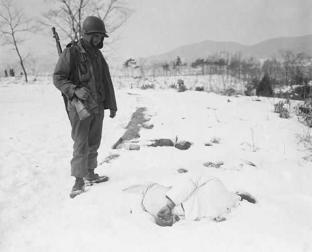 美军士兵在雪地中发现被朝鲜人民军杀害的韩国平民尸体