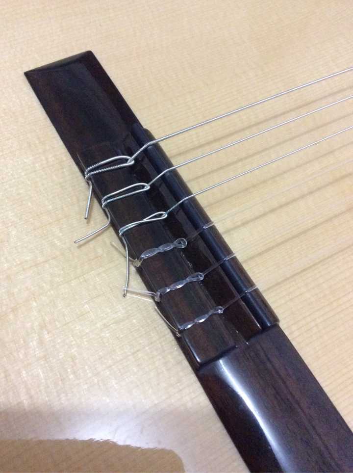 古典吉他传统缠绕式绑弦与这种方式各有什么利弊?