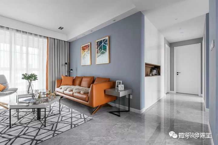 蓝灰色沙发墙搭配橘色皮质沙发,简单挂画,空间现代时尚