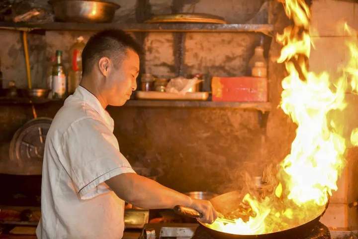 2015年9月2日,四川内江,正在炒菜的厨师.