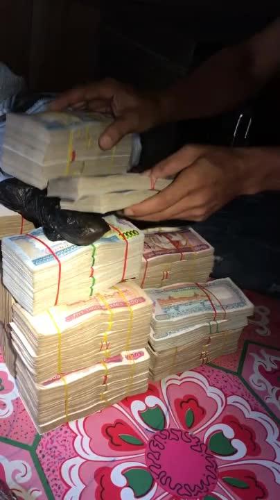 翡翠原石赌石:在缅甸谈好货 缅币一般都是用麻袋扛过去的 货主用钱敲