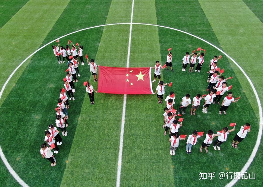 拍江西省上饶市铅山县河口五小学生在操场摆圆形,与国旗合影,庆祝国庆