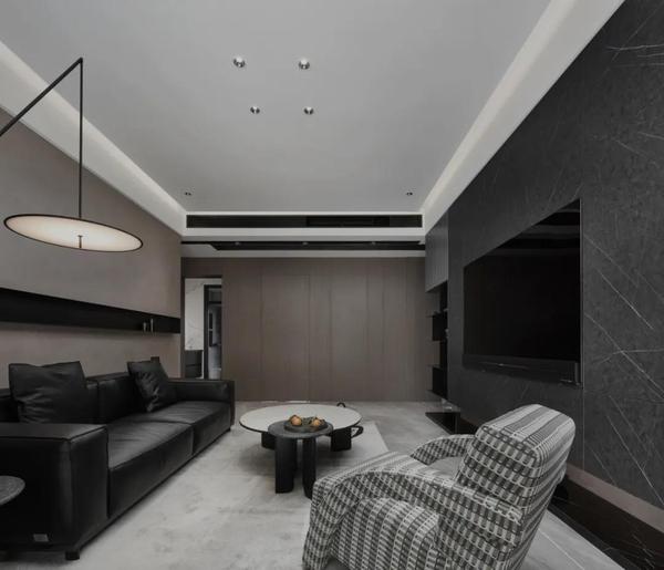 客厅空间,电视背景墙以深灰色为主,极具美感与收纳功能.