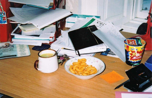 一个标准的办公桌,除了有杂七杂八的文件,还少不了各种饮料零食