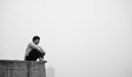 黑色裤子,赤着双脚,独自坐在重庆朝天门码头,向远处深情凝望的男人