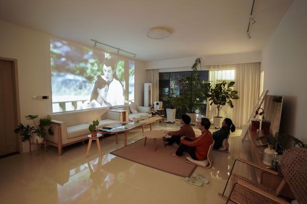 小面利用沙发背景墙面的空间制作了一个巨型隐形幕布投影墙,家里人对