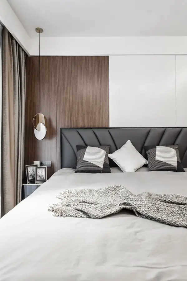 床头背景使用天然木饰面与白色烤漆墙板做拼接,呼应了客厅的风格造型