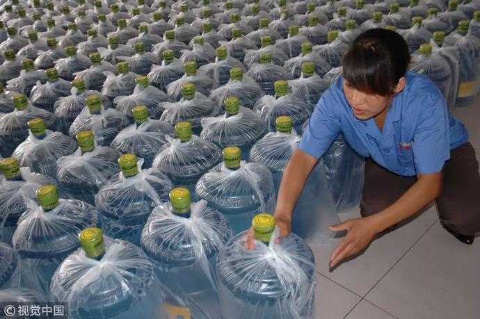 河南省汤阴县一纯净水厂工作人员正在向外运送桶装纯净水 / 视觉中国
