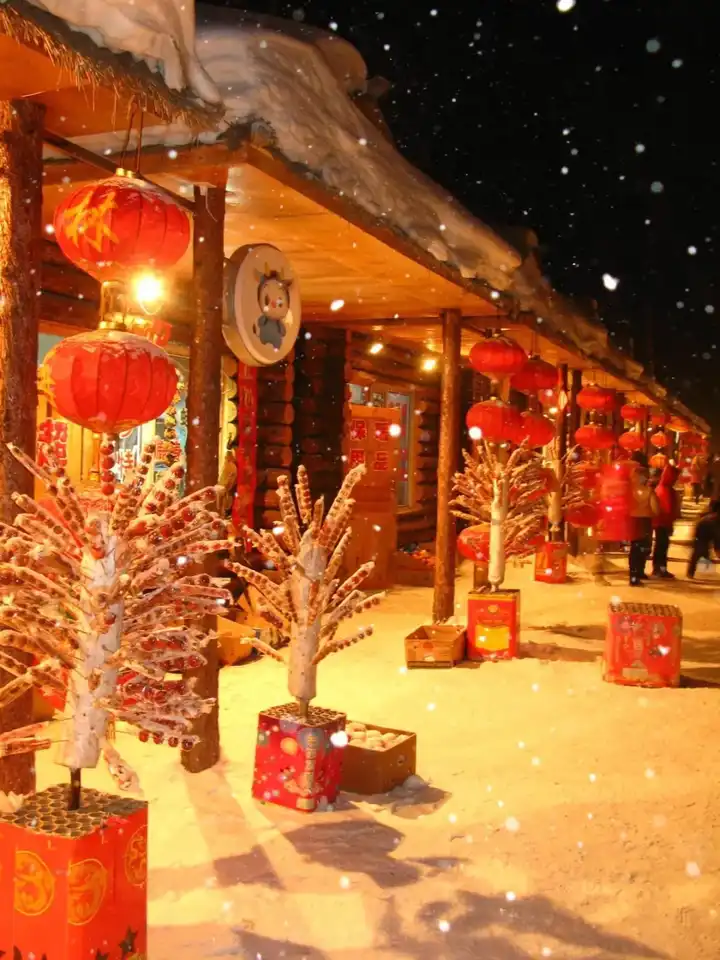 夜晚,家家门前都挂起大红灯笼,洁白的雪花漫天飞舞,在灯笼的照耀下
