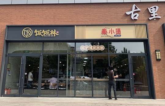 两个比邻而居的新快餐品牌"饭饭林"和"秦小贤",饭饭林主营川味盖浇饭