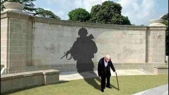 一个老人拿着拐杖,影子是一个军人,黑白的,外国的?