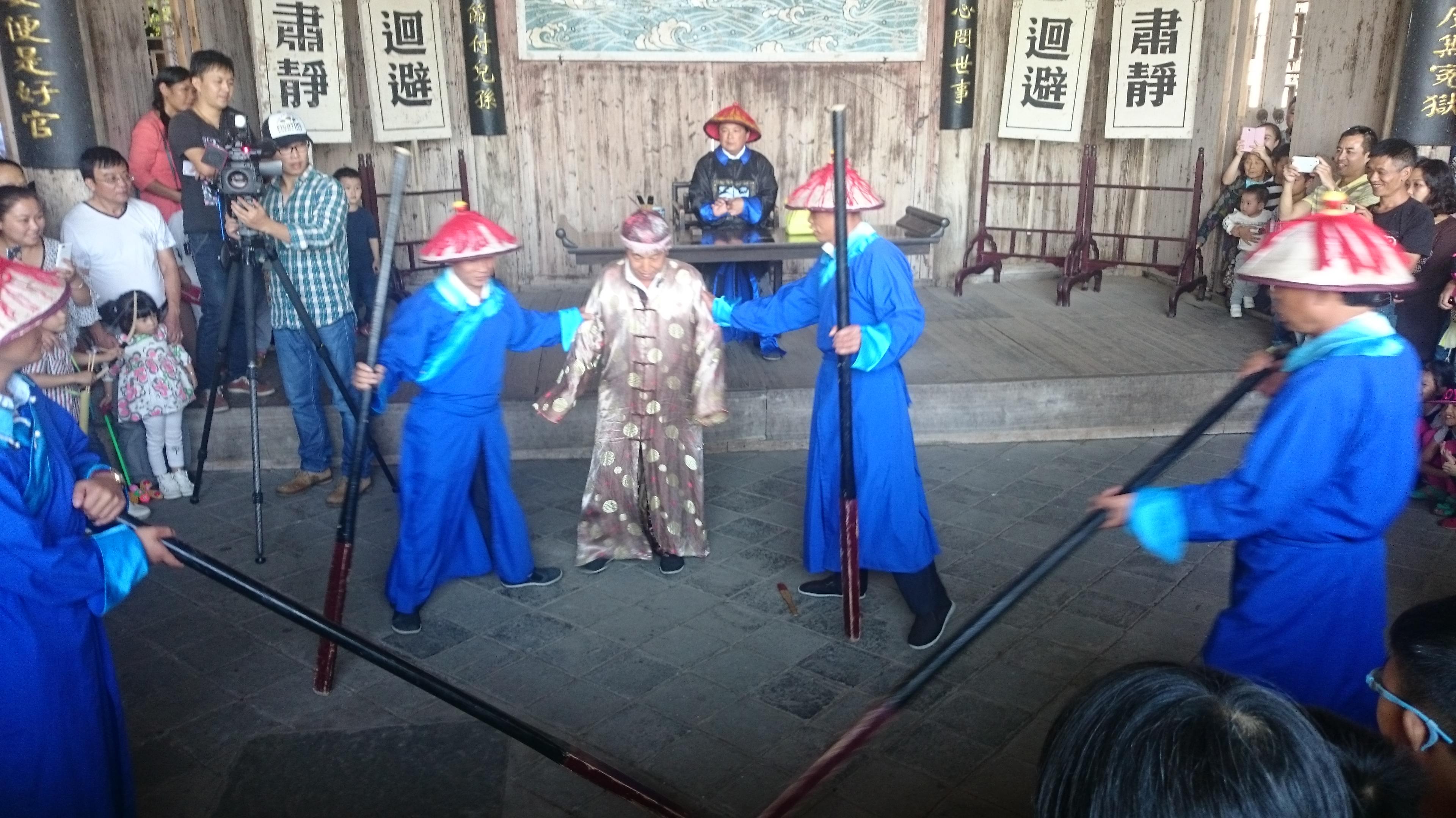 场演出,所谓演出,就是工作人员穿上戏服,上演一出县官升堂判案的表演