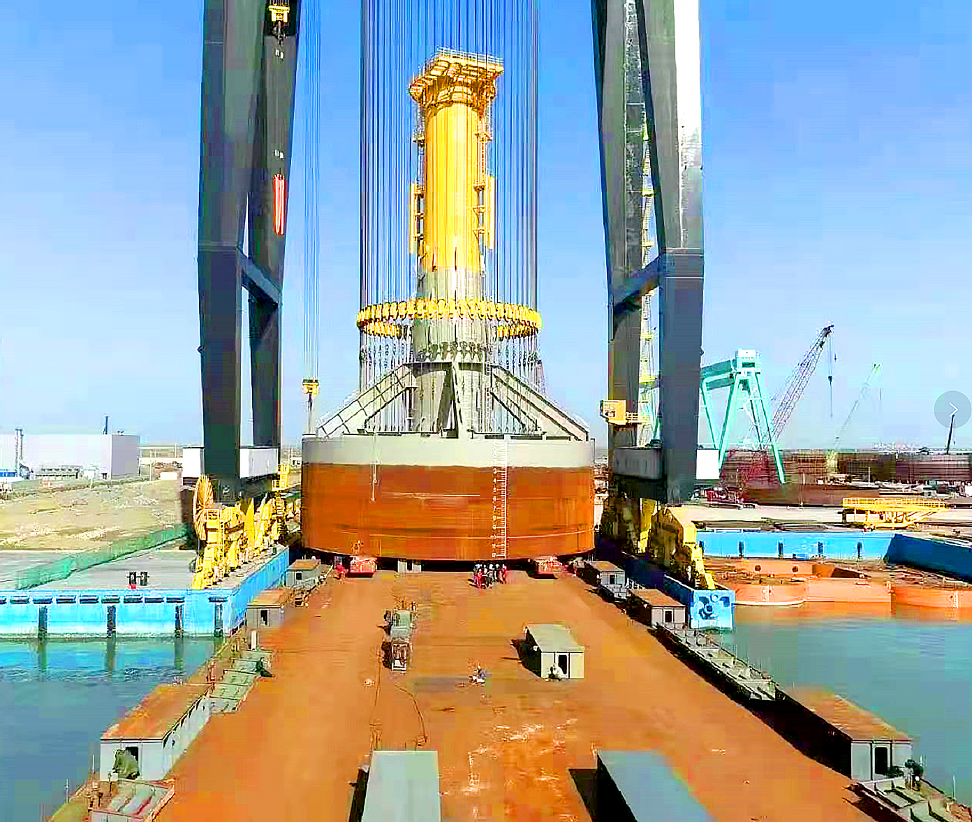 spmt车组动员至驳船甲板待命;龙门吊吊运第一座复合筒形基础结构,放置