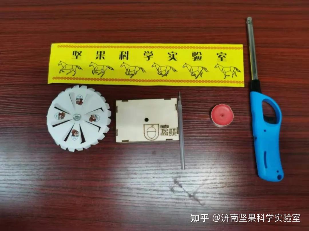 圆形纸片1个,蜡烛1支,圆珠笔芯1根,小刀1把,双面胶,打火机,小纸盒(做
