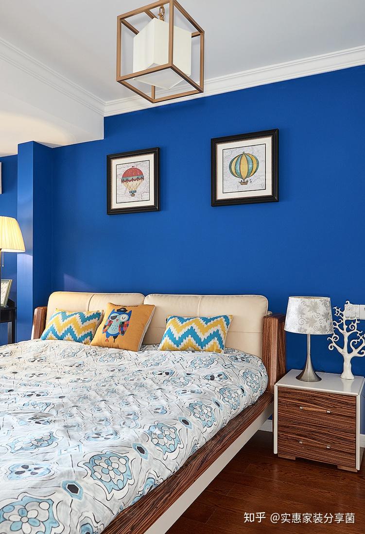 采用饱满的深蓝色作为卧室的墙面色彩,简洁的装饰画与柠檬黄的配色