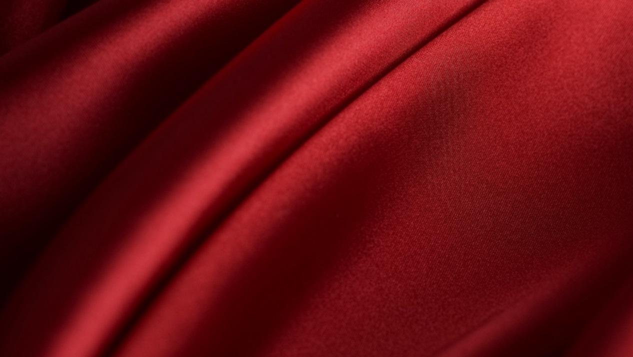 因为背景使用了红色丝绸,富有明暗变化,视觉信息量比较多.