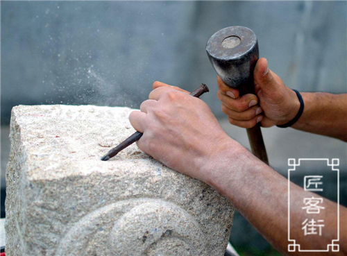 上半年是碑刻行业旺季,在他的身边,石材码成了"小山",机器打磨石头的