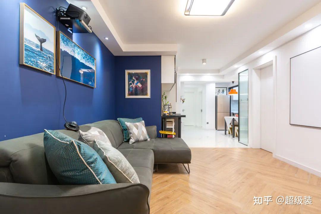 墨蓝色的背景墙,以及低饱和度的家居配色,营造温柔的起居氛围.