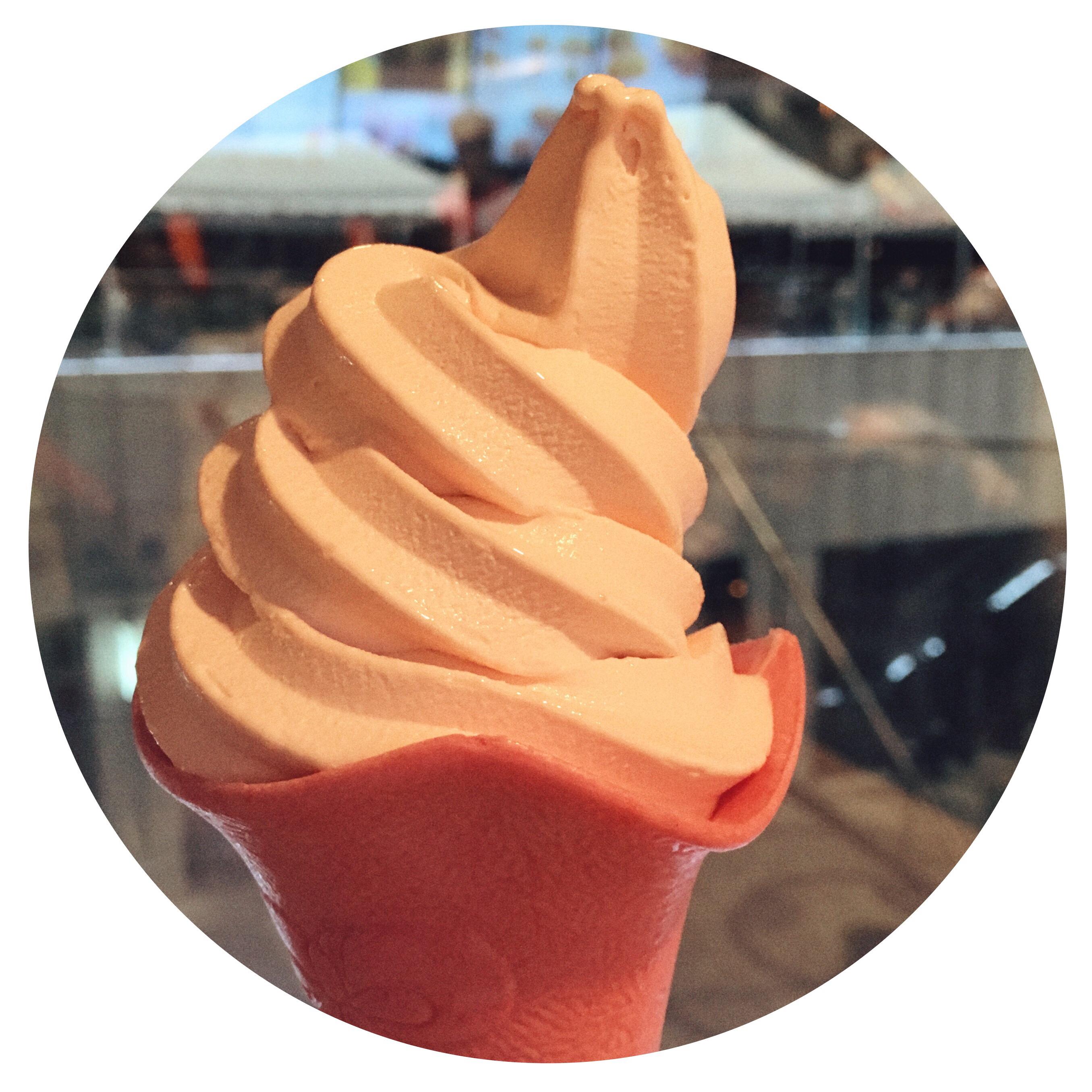 一个四五岁的小男孩应该是刚买了一个甜筒,从队伍前