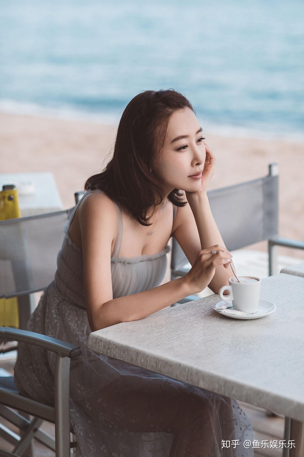 照片中毛俊杰在海边嬉戏玩耍,一身白色纱裙简单不失仙气,凸显了小女人