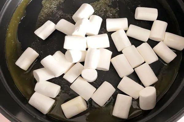 4,不粘锅中倒入黄油,开小火,待黄油融化后倒入棉花糖;5,棉花糖完全