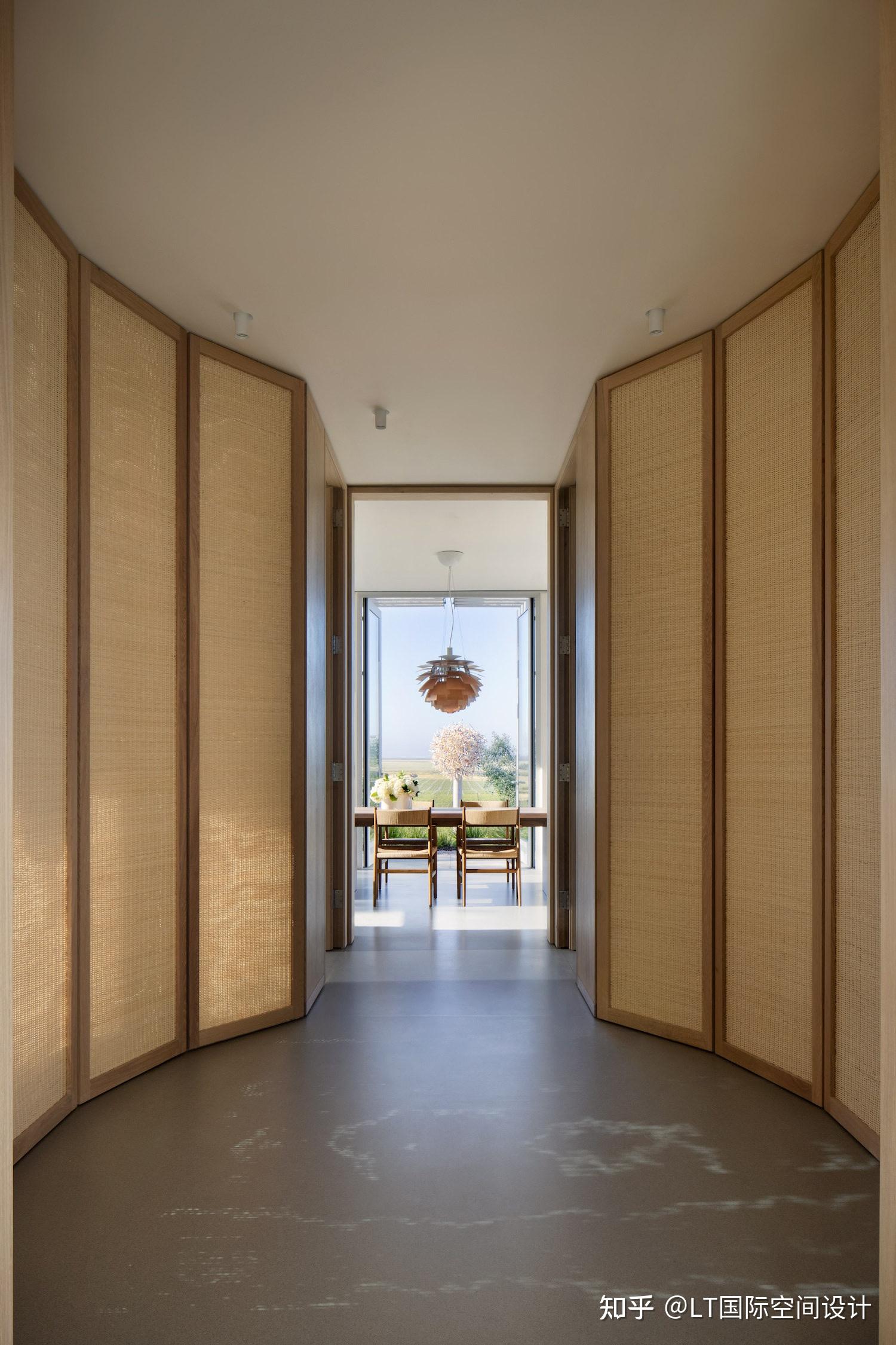 轴线对称的空间布置大面积原木色藤编元素搭配经典款家具和艺术品太