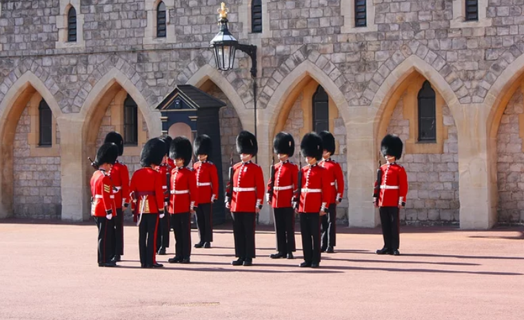 今日英国王室的禁卫军依旧保留着鲜亮的红色制服和复古的熊皮帽每天