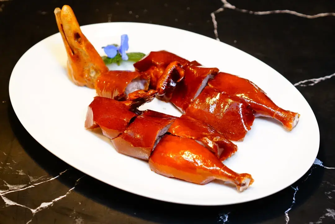 炭烤乳鸭选用广西玉林的乳鸭,淋滚油的手法将乳鸭"炸"熟,鸭肉不会过多