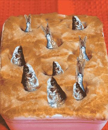 诡异地从烤过的派中探出头来,就像是一群鱼睁着大眼在仰望星空,因此被