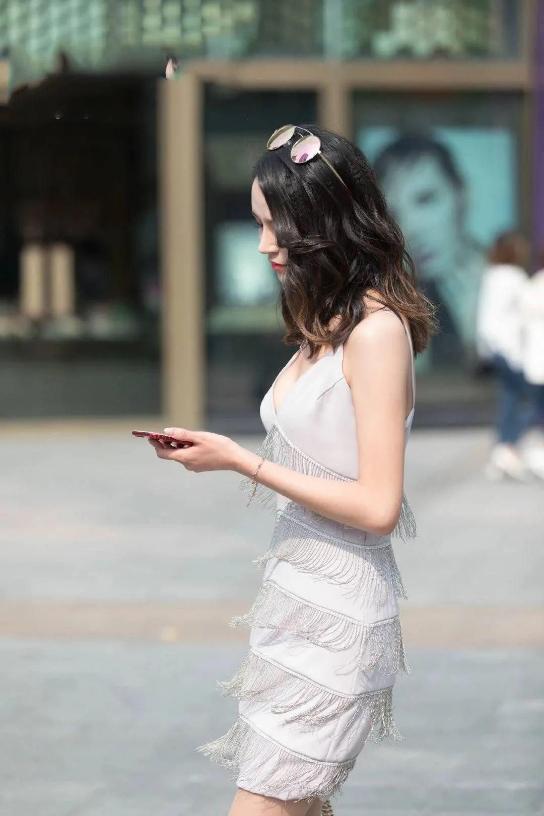 街拍女神吊带短裙的卷发漂亮女生