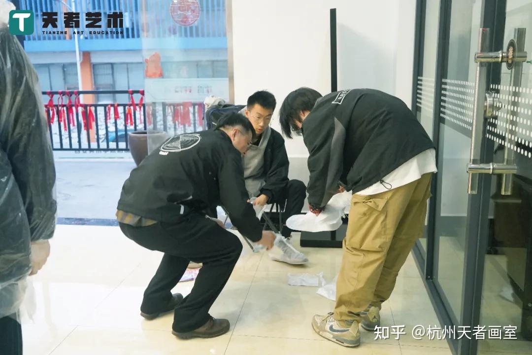 (肖老师帮同学们穿雨鞋)(裘老师帮同学们穿雨衣)专业老师们也赶到考