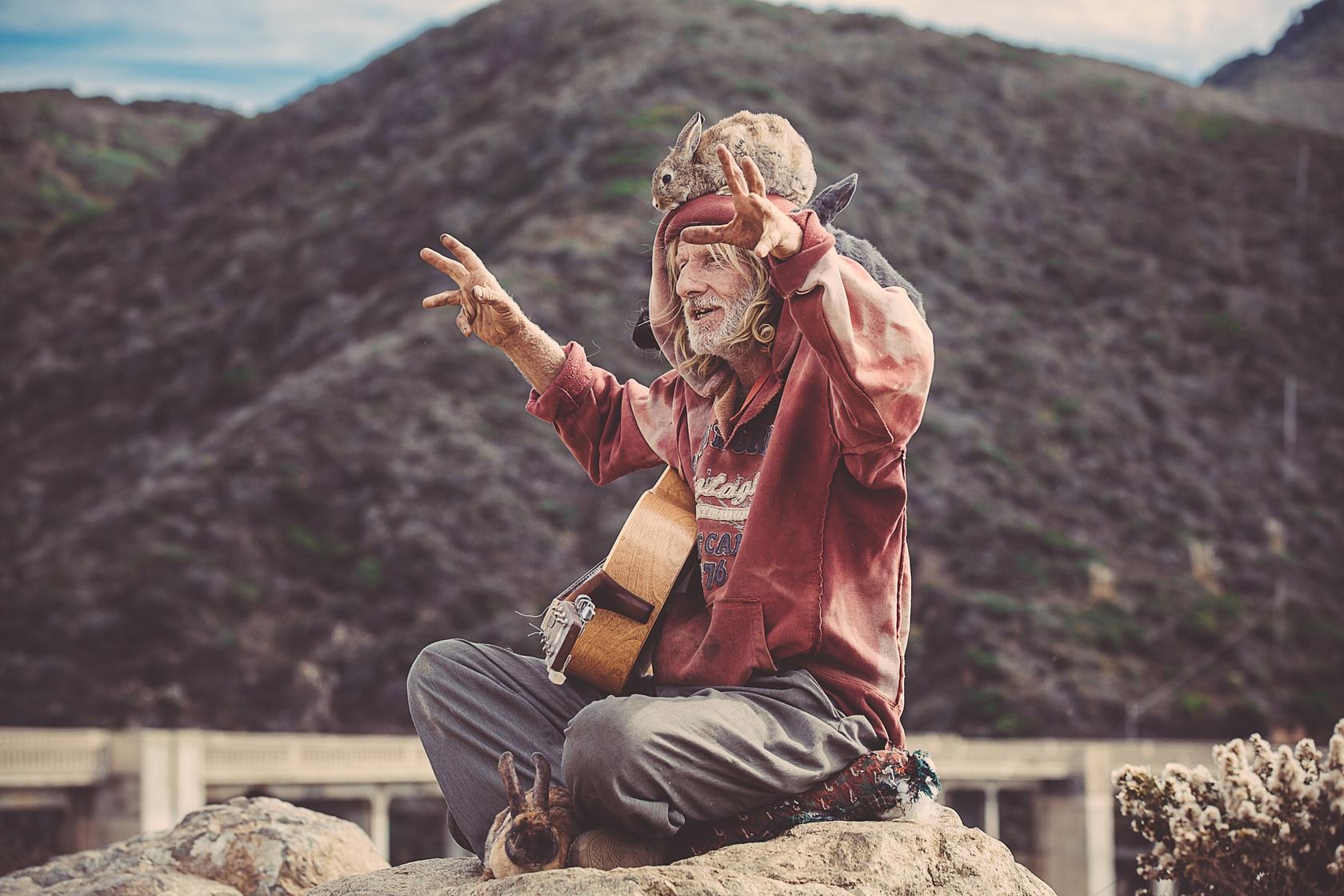 头顶兔子在山顶弹吉他的老人的图片的意义?